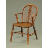 A 19th century yew wood Windsor chair, with solid seat and raised on turned legs with stretchers.