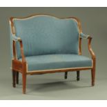 A Georgian mahogany framed settee, of shaped outline, with upholstered back,
