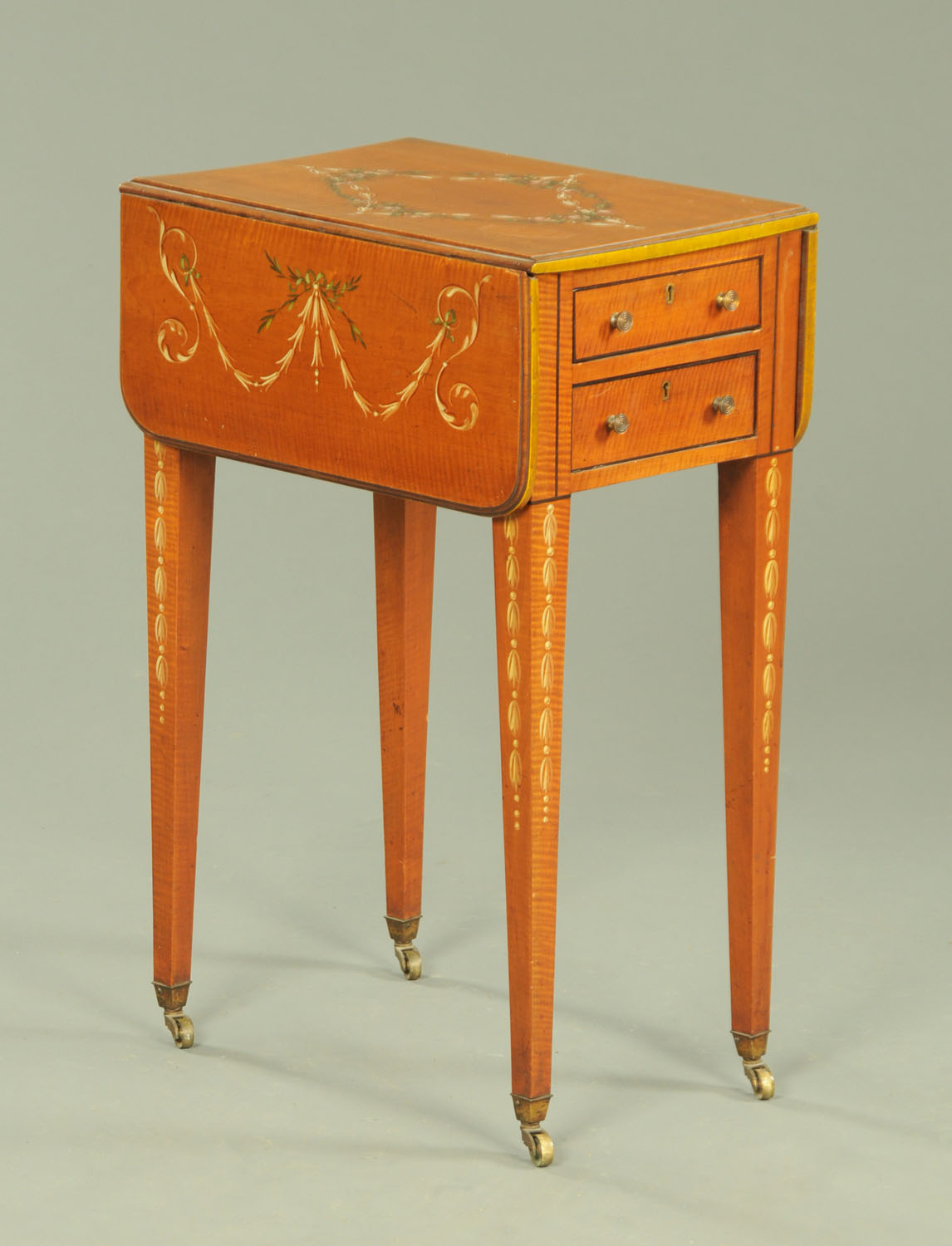A 19th century painted satinwood work table, with elliptical drop leaves,