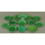 A collection of 19th century green Majolica strawberry leaf dessert plates and a tazza,
