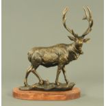 A cast metal elk, in gilt and black finish on a wood base. Height 50 cm.