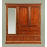 An Edwardian Maple's walnut wardrobe, with detachable moulded cornice above a series of cupboards,