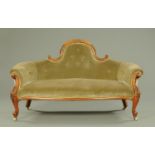 A Victorian upholstered settee, with carved walnut showframe,