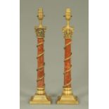 A pair of red serpentine and cast metal mounted Classical style table lamps, each on a square base.
