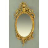 A 19th century giltwood and gesso oval mirror, with moulded frame and mask,
