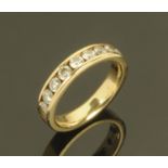 A 14 ct gold ring with 9 channel set diamonds, ring size M, 5.1 grams gross weight.