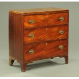 A George III mahogany chest of three long graduated drawers,