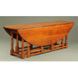 A large walnut or yew wood wake type table, twin drop flap. 227 cm x 55 cm folded, open 103 cm.