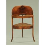 A George III mahogany corner washstand, of typical form,