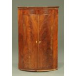 A George III mahogany bow front corner cupboard,