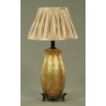 A modern table lamp, simulating planished brass upon a faux bamboo stand,