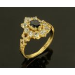 An 18 ct yellow gold sapphire and ring, with central sapphire framed by 10 diamonds. size M.