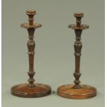 A pair of Edwardian carved and turned mahogany candlesticks,