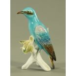 A Karl Ens porcelain model of a roller bird, perched on a leafy branch. 21 cm high.