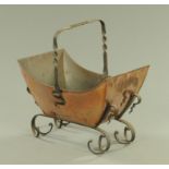 A Victorian Arts & Crafts boat shape copper log bin, with wrought iron handle and scrolling feet.