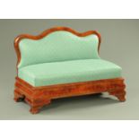 A Victorian mahogany framed boudoir settee, having a shaped back rest,