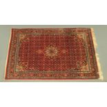 A Persian red ground rug, with central floral medallion,