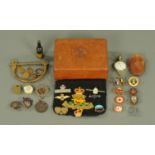 A wooden box carved with the emblem of The Royal Fusiliers, containing a quantity of badges,