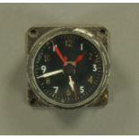 A World War II fighter cockpit clock, with luminous white hands, a further set of red hands,