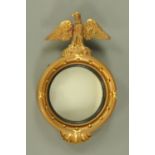 An early 20th century Regency style gilt convex mirror, the mirror within an ebony slip,