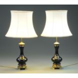 A pair of carved wood and gilt metal mounted table lamps and shades, 20th century,