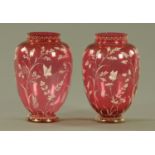 A pair of Victorian cranberry glass vases, decorated with stems and butterflies. Height 18 cm.