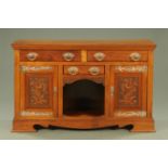 An Arts & Crafts walnut sideboard, fitted with a series of drawers,