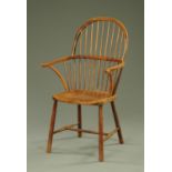 A 19th century Windsor armchair, with tall arched back, slim arms with scroll terminals,