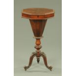 A Victorian rosewood worktable, octagonal, with faceted column and foliated carved cabriole legs.