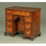 A George III walnut kneehole desk, with crossbanded moulded edge above a frieze drawer,