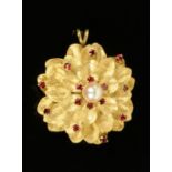 A 9 ct gold pearl and garnet set floral brooch, with hinged pendant mount, 8.4 grams.