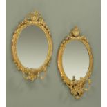 A pair of Victorian giltwood and gesso oval wall mirrors, with candle sconces.