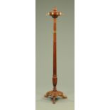 A Victorian mahogany coat stand, with urn finial above a revolving top with brass scroll hooks,