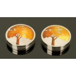 A pair of silver and enamel pillboxes, of circular form, the lids enamelled with oak trees,