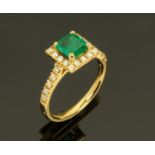 An 18 ct yellow gold emerald and diamond cluster ring, emerald +/- .