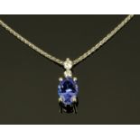 An 18 ct white gold pendant set with an oval tanzanite to diamond set bail, total weight +/- 1.