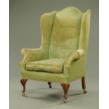 A Queen Anne style wing armchair, with short cabriole legs on shepherds castors, 90 cm wide,