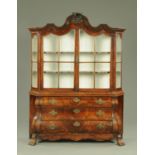 A Dutch walnut display cabinet, of bombe form, with pair of doors opening to shaped shelves,