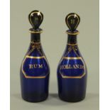 A pair of early 19th century Bristol blue decanters, each with stopper, Rum and Hollands.