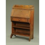 An Arts and Crafts oak students desk, circa 1900, the pediment with pierced heart shaped motif,