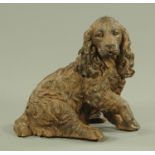 A composition moulded figure of a spaniel, seated on its haunches with its front right paw raised.