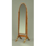 A mahogany framed cheval mirror, with turned finials to each upright and raised on downswept legs.