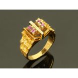 An 18 ct Continental gold ring, set with four small rubies separated by a white metal bar,