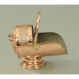 A Victorian embossed copper coal scuttle, with loop carrying handle (see illustration).