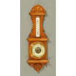 A late Victorian carved oak barometer, with milk glass thermometer, 65 cm.