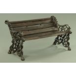 A Victorian style cast iron garden bench, with wooden slats and scroll ends. Width 124 cm.