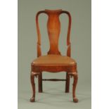 A George I carved walnut dining chair, with a slightly scrolling top rail above a vase shaped splat,