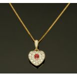 An 18 ct yellow gold ruby and diamond heart shaped pendant on fine link chain.