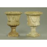 A pair of stoneware garden urns, of campana form and raised on a square base.