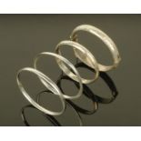 Four silver bangles, two hinged with engraved decoration.
